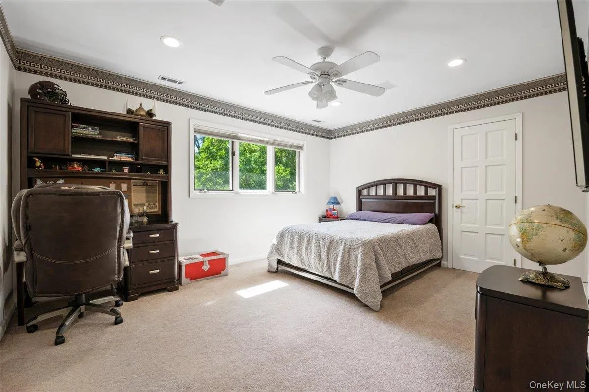 Bedroom with light colored carpet, ornamental molding, ceiling fan, a desk, and recessed lighting Bedroom with light colored carpet, ornamental molding, ceiling fan, a desk, and recessed lighting