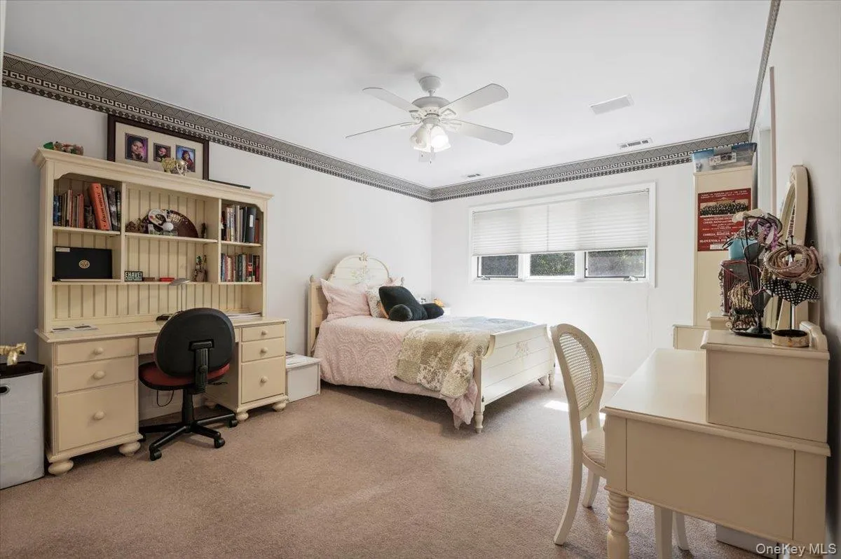 Bedroom featuring carpet flooring, ceiling fan, and an office area Bedroom featuring carpet flooring, ceiling fan, and an office area