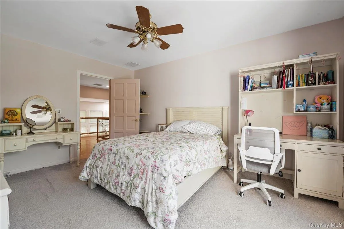 Bedroom with light carpet, an office area, and a ceiling fan Bedroom with light carpet, an office area, and a ceiling fan