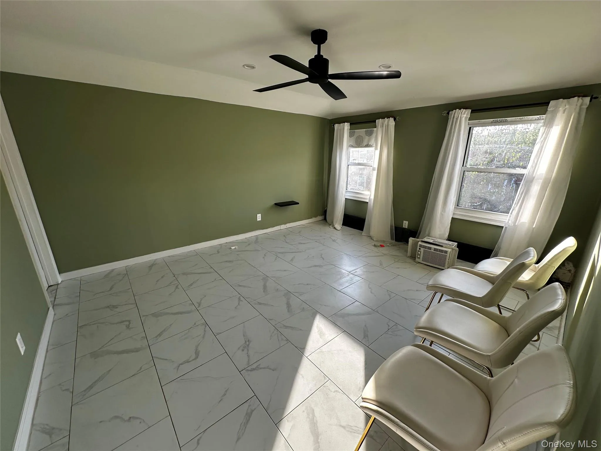 Unfurnished room featuring light marble finish flooring and a ceiling fan Unfurnished room featuring light marble finish flooring and a ceiling fan