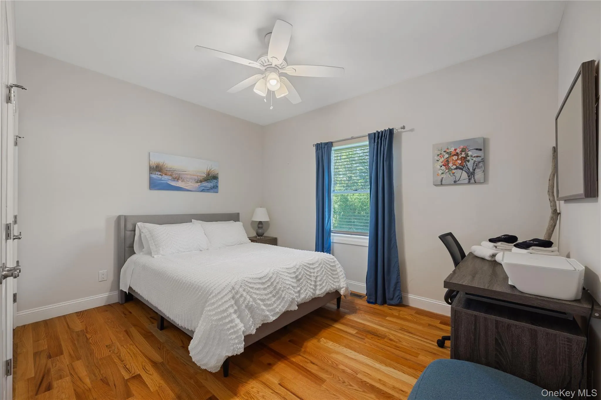 Bedroom featuring light wood finished floors and a ceiling fan Bedroom featuring light wood finished floors and a ceiling fan