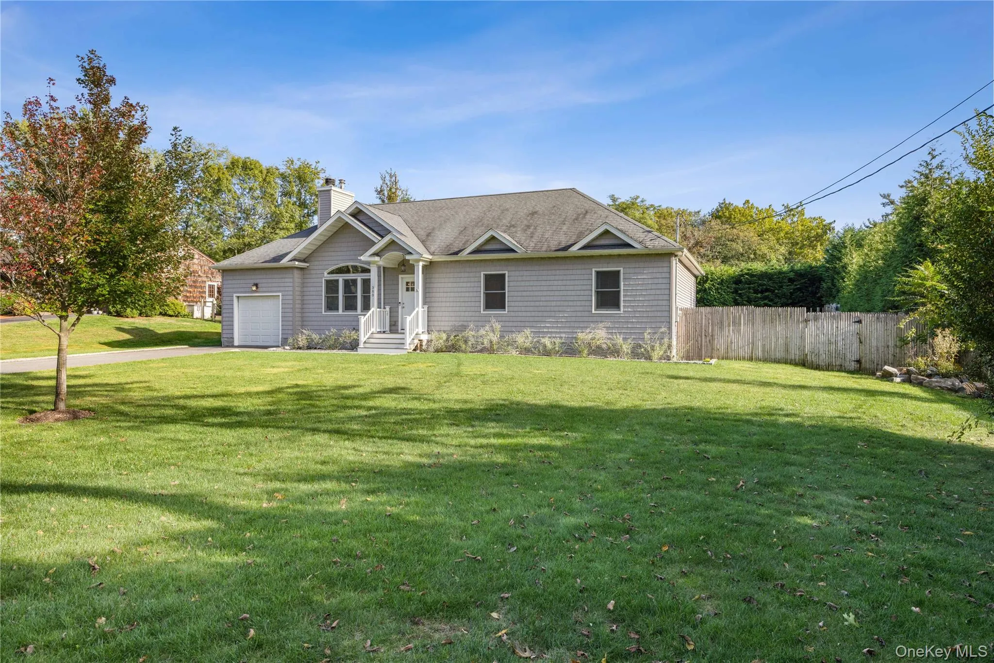 Ranch-style house with a chimney, a garage, and driveway Ranch-style house with a chimney, a garage, and driveway