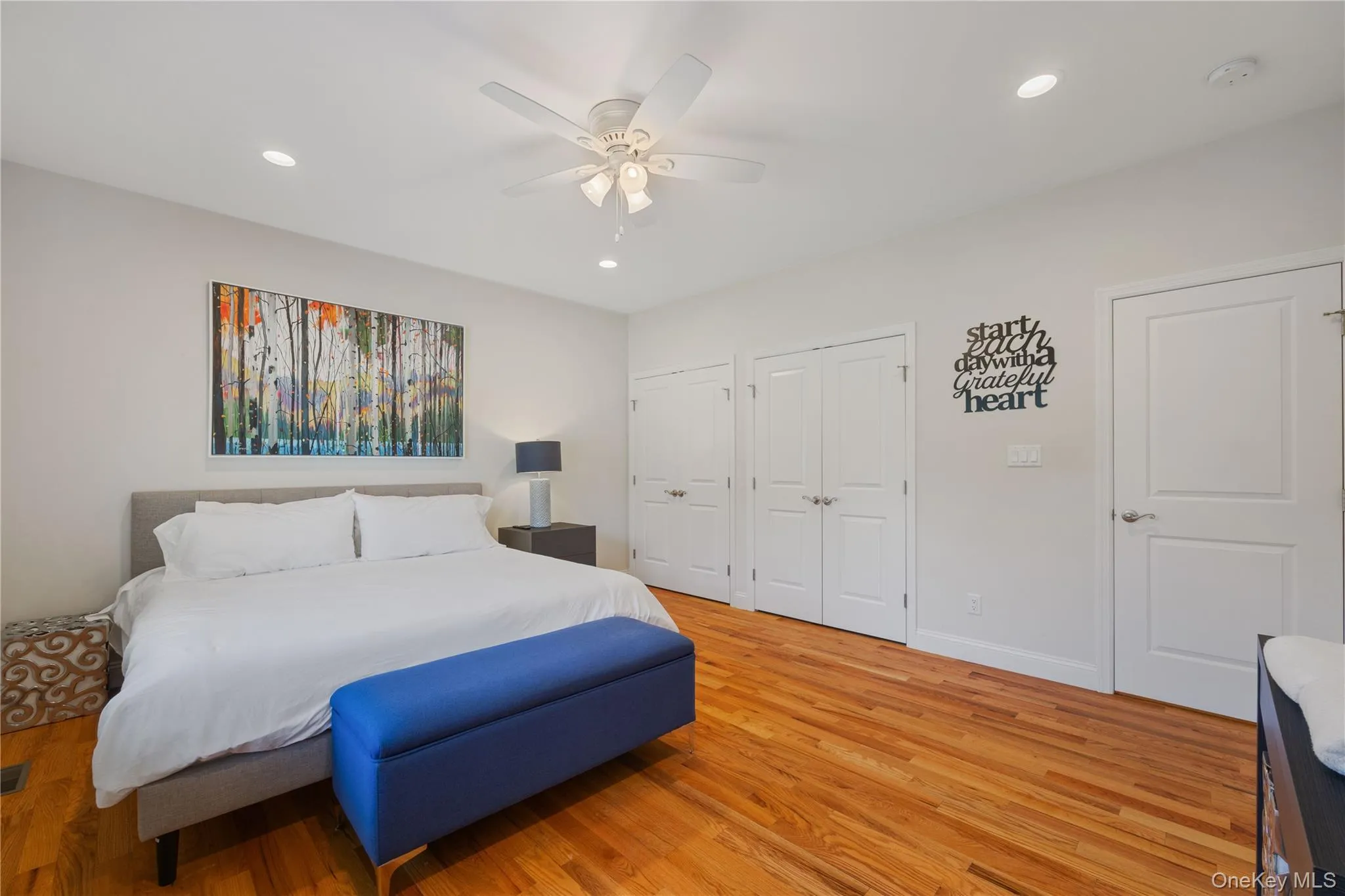 Bedroom with two closets, recessed lighting, wood finished floors, and a ceiling fan Bedroom with two closets, recessed lighting, wood finished floors, and a ceiling fan