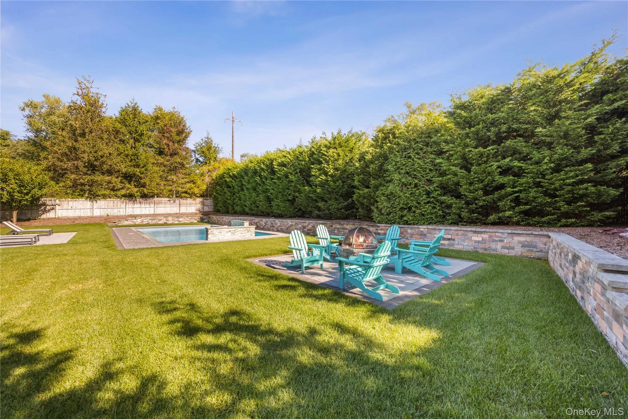 Fenced backyard featuring a patio and an outdoor fire pit Fenced backyard featuring a patio and an outdoor fire pit