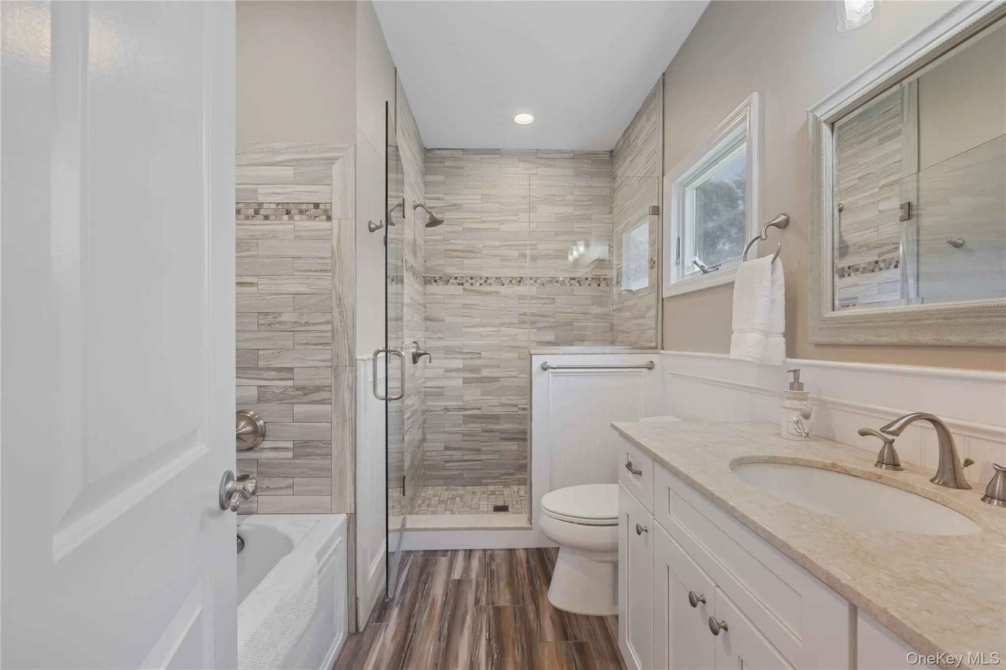 Bathroom featuring a shower stall, vanity, a bath, dark wood-type flooring, and recessed lighting Bathroom featuring a shower stall, vanity, a bath, dark wood-type flooring, and recessed lighting