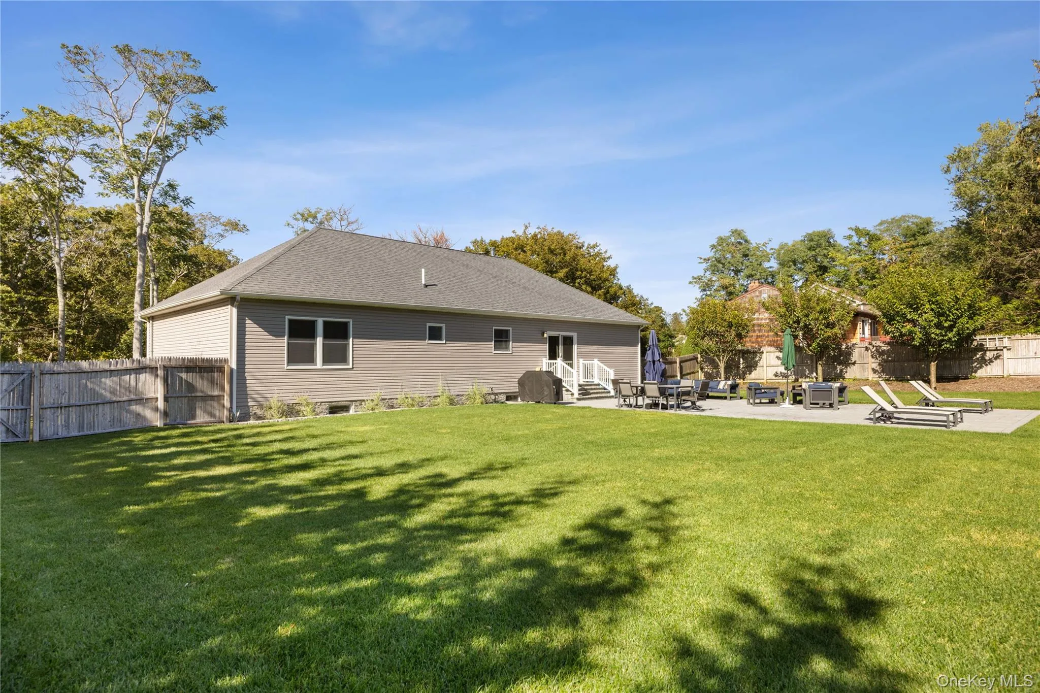Rear view of property featuring a fenced backyard, a patio area, and a shingled roof Rear view of property featuring a fenced backyard, a patio area, and a shingled roof