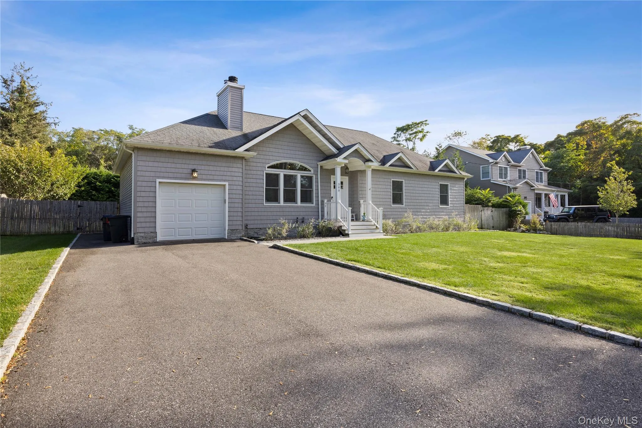 Single story home with asphalt driveway, a shingled roof, a chimney, and an attached garage Single story home with asphalt driveway, a shingled roof, a chimney, and an attached garage