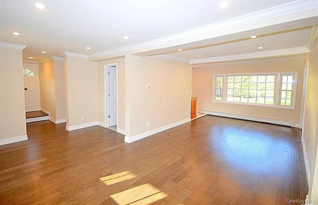 Spare room with ornamental molding, baseboard heating, dark wood-type flooring, and recessed lighting Spare room with ornamental molding, baseboard heating, dark wood-type flooring, and recessed lighting