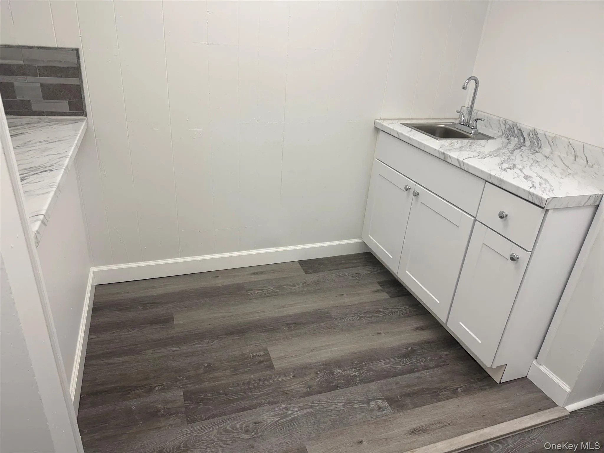Laundry room with dark wood finished floors and baseboards Laundry room with dark wood finished floors and baseboards