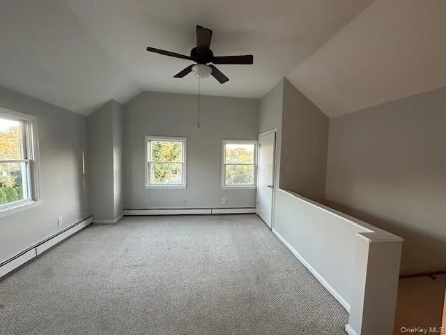 Bedroom with carpet flooring, vaulted ceiling, a ceiling fan, and baseboard heating Bedroom with carpet flooring, vaulted ceiling, a ceiling fan, and baseboard heating
