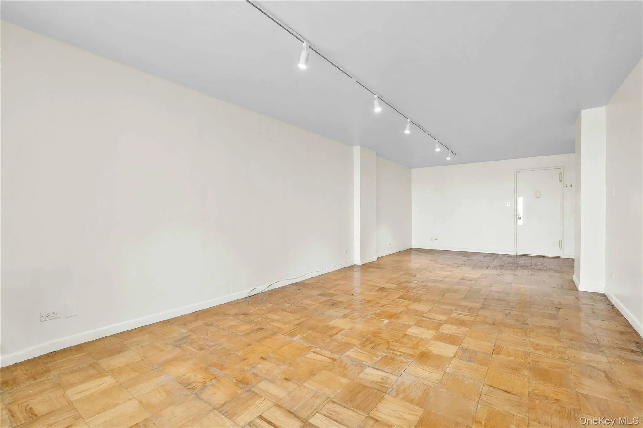 Spare room featuring baseboards and rail lighting Spare room featuring baseboards and rail lighting