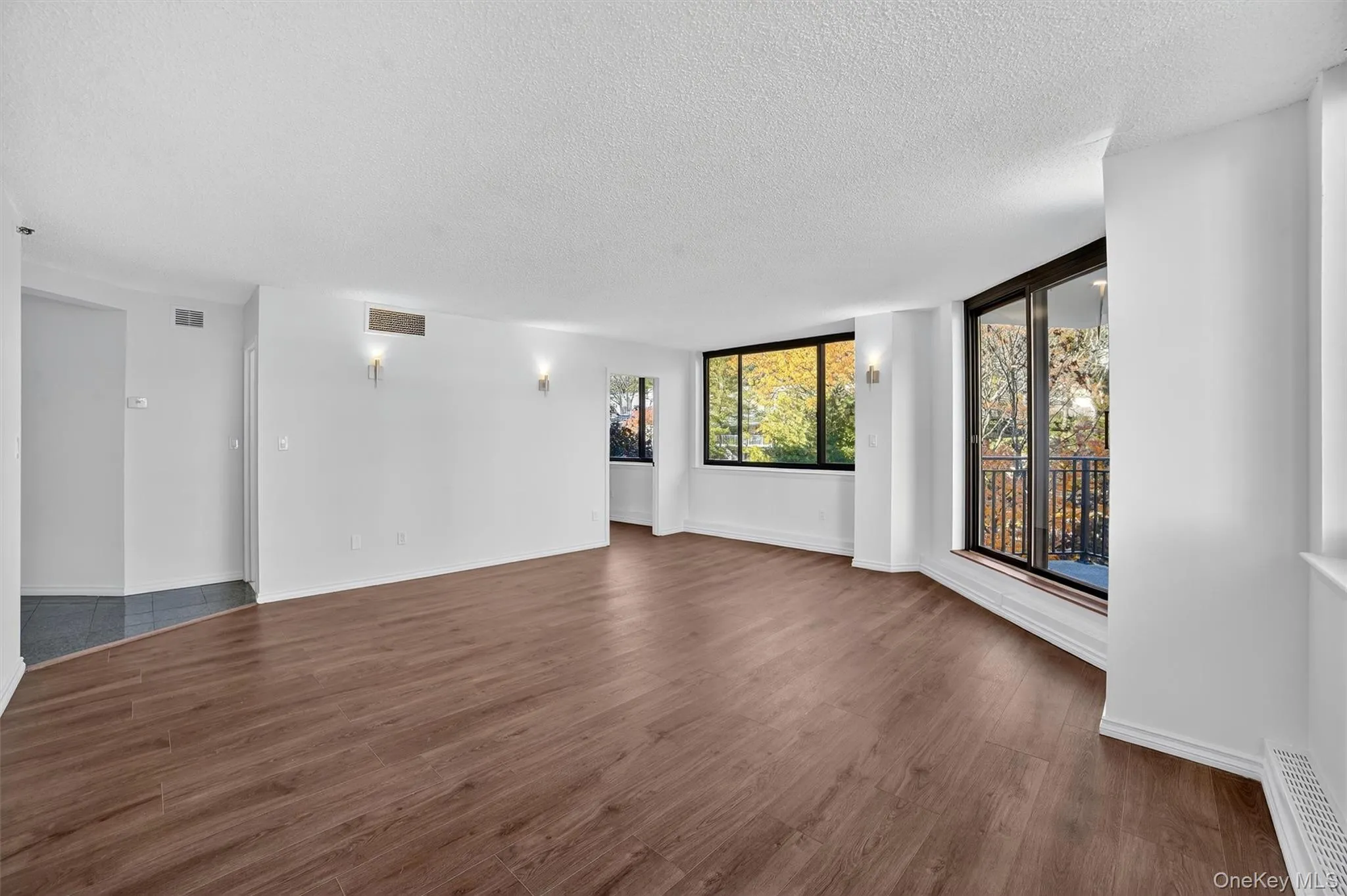 Unfurnished room with dark wood-style floors and a textured ceiling Unfurnished room with dark wood-style floors and a textured ceiling