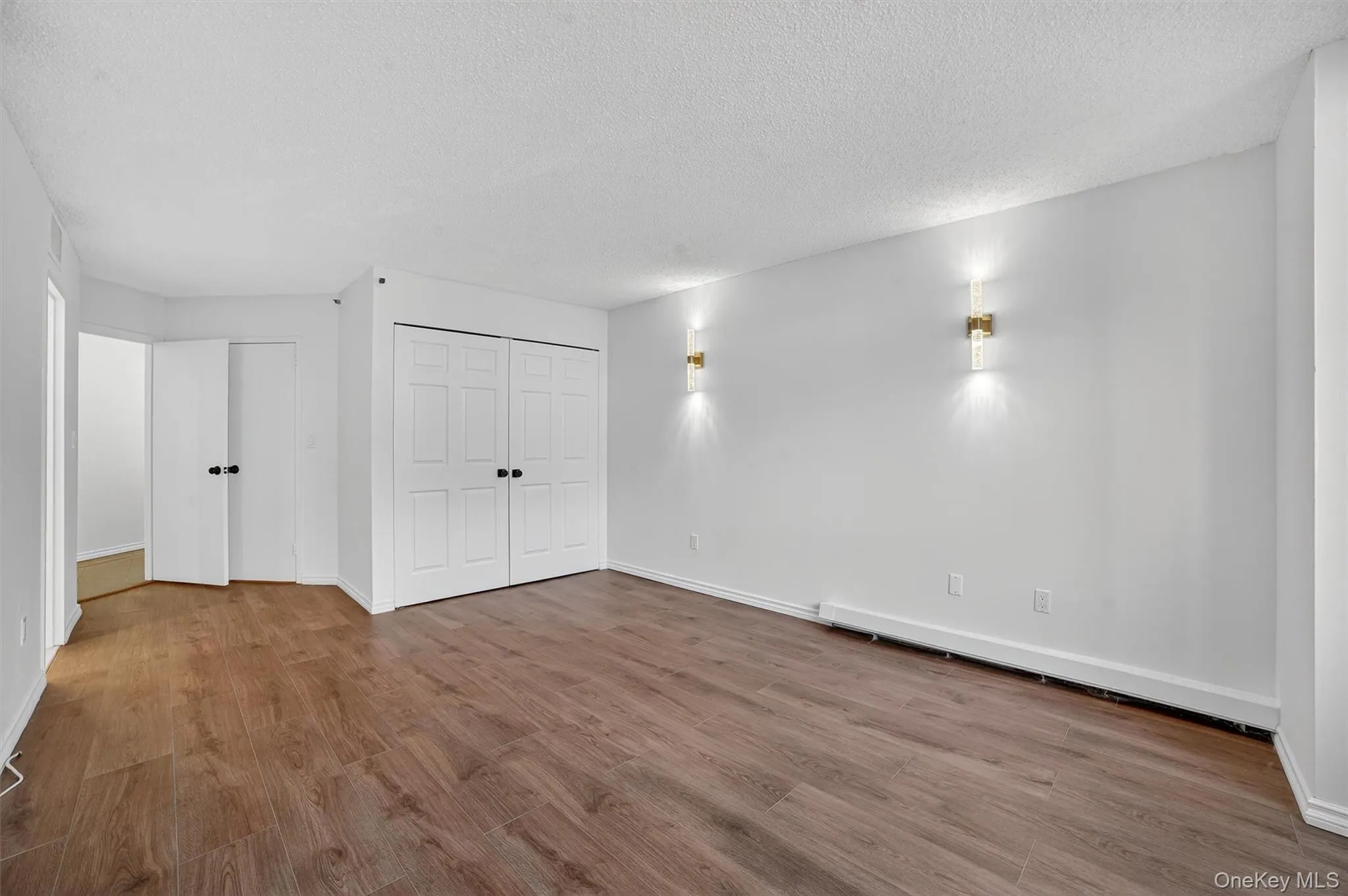 Below grade area with wood finished floors and a textured ceiling Below grade area with wood finished floors and a textured ceiling