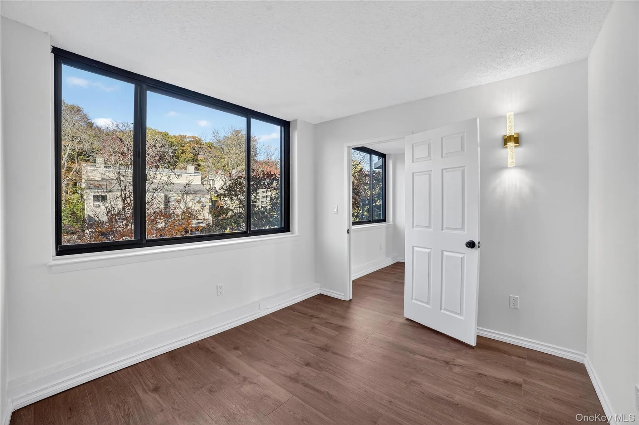 Unfurnished bedroom featuring dark wood-type flooring and a textured ceiling Unfurnished bedroom featuring dark wood-type flooring and a textured ceiling