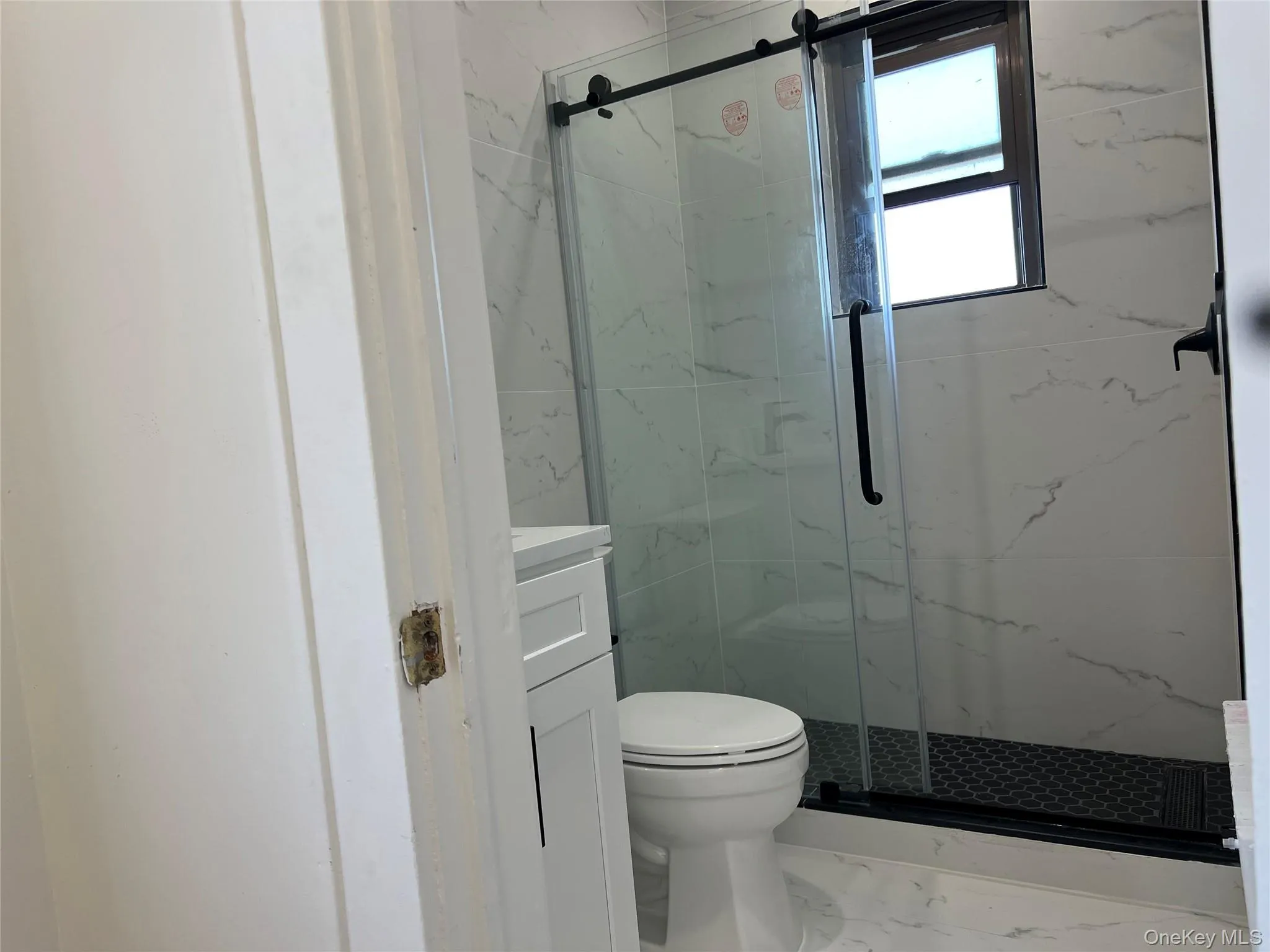 Bathroom with vanity, a marble finish shower, and marble finish flooring Bathroom with vanity, a marble finish shower, and marble finish flooring