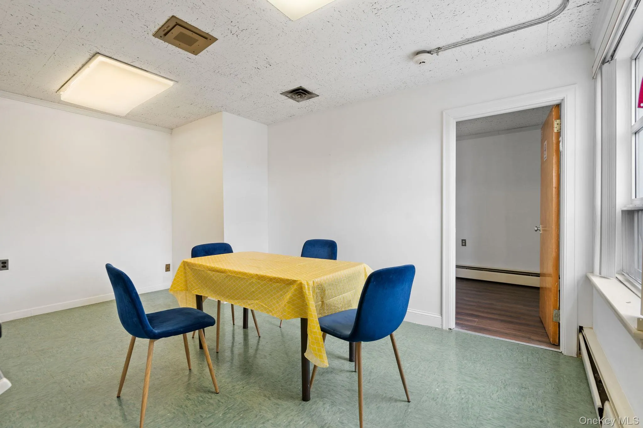 Home office featuring a baseboard radiator, a textured ceiling, and tile patterned floors Home office featuring a baseboard radiator, a textured ceiling, and tile patterned floors