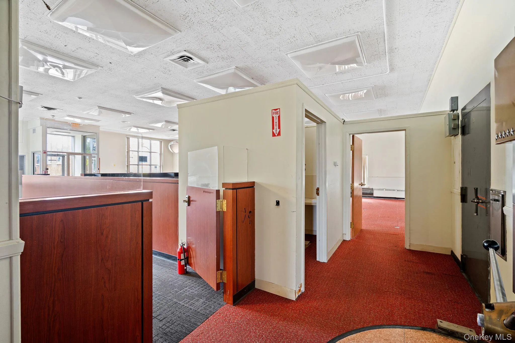 Corridor featuring dark carpet and a textured ceiling Corridor featuring dark carpet and a textured ceiling