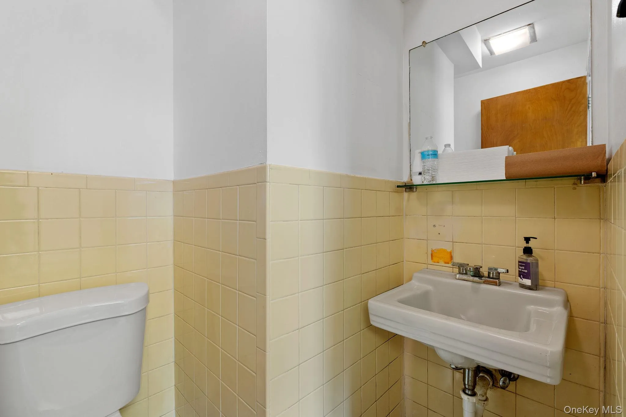 Bathroom with tile walls and a wainscoted wall Bathroom with tile walls and a wainscoted wall