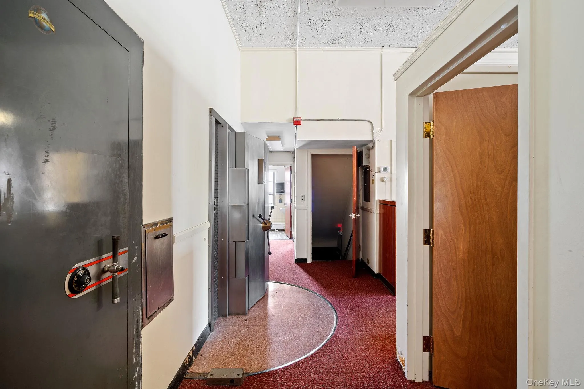 Hall featuring dark colored carpet Hall featuring dark colored carpet