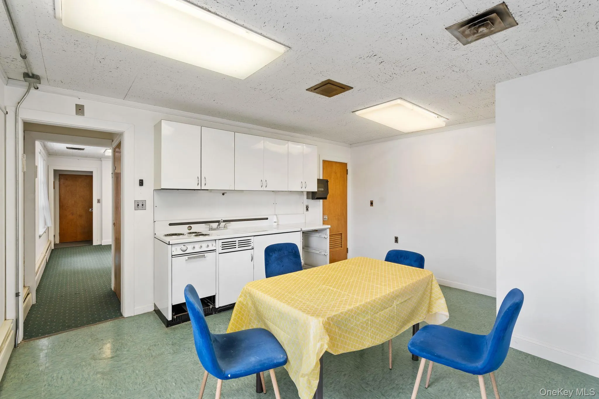 Dining area featuring dark flooring, a textured ceiling, and baseboard heating Dining area featuring dark flooring, a textured ceiling, and baseboard heating
