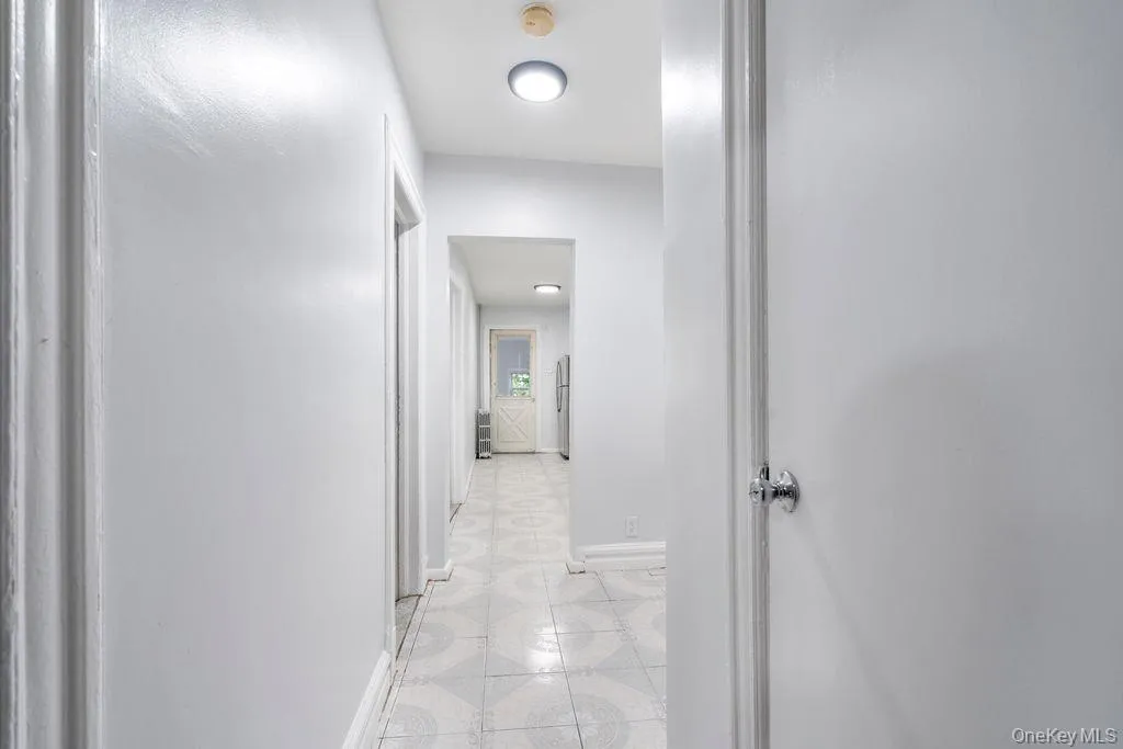 Corridor with baseboards and light tile patterned floors Corridor with baseboards and light tile patterned floors