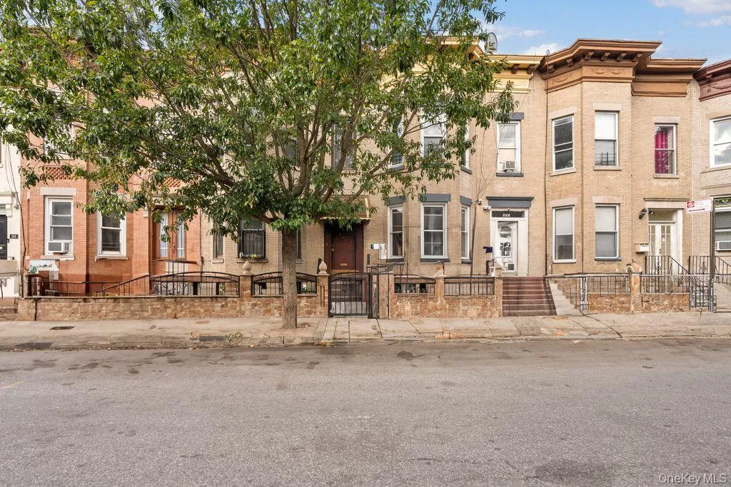 Italianate house featuring a fenced front yard, a gate, and brick siding Italianate house featuring a fenced front yard, a gate, and brick siding