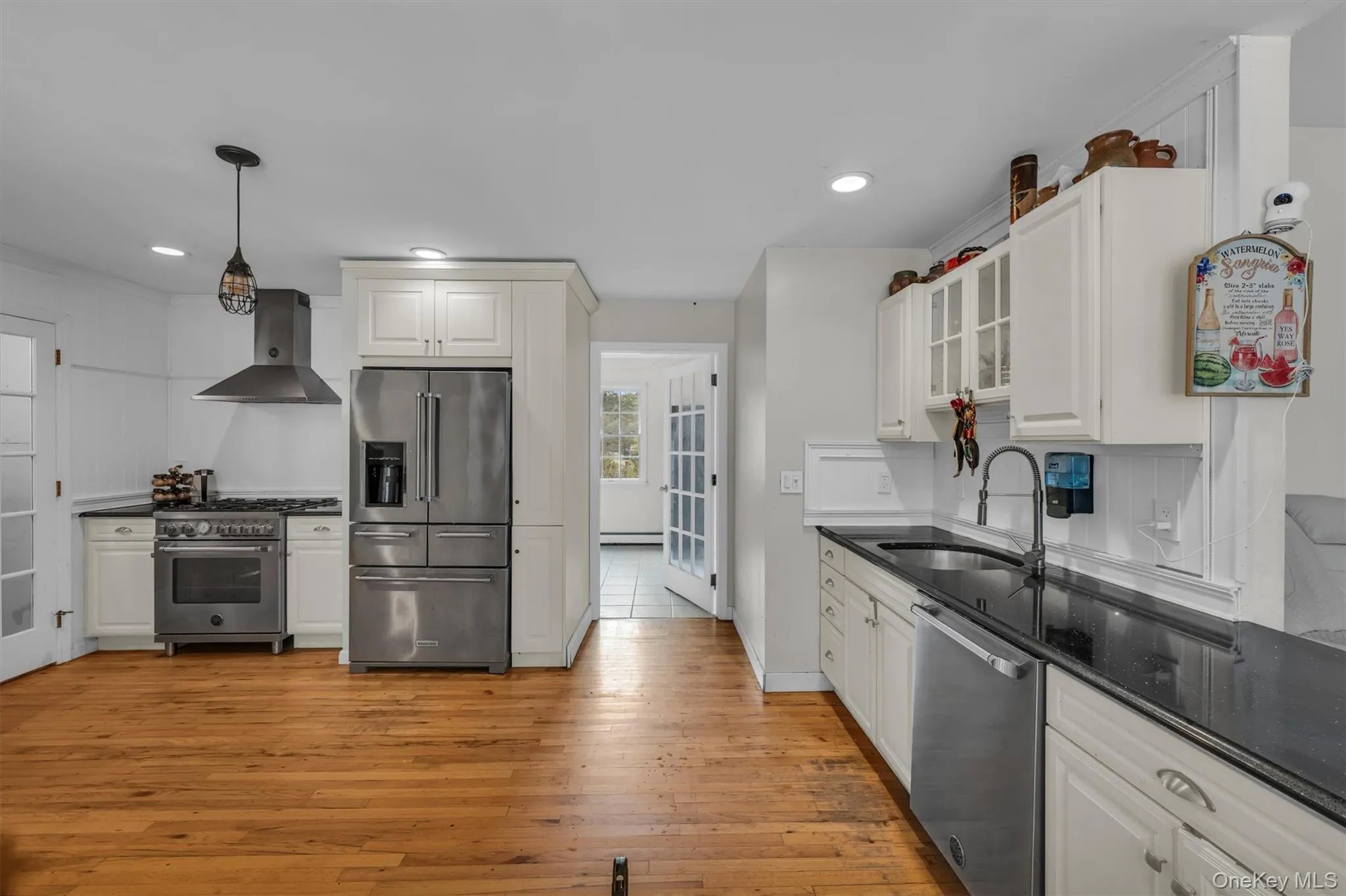 Kitchen featuring high quality appliances, glass insert cabinets, white cabinets, and recessed lighting Kitchen featuring high quality appliances, glass insert cabinets, white cabinets, and recessed lighting