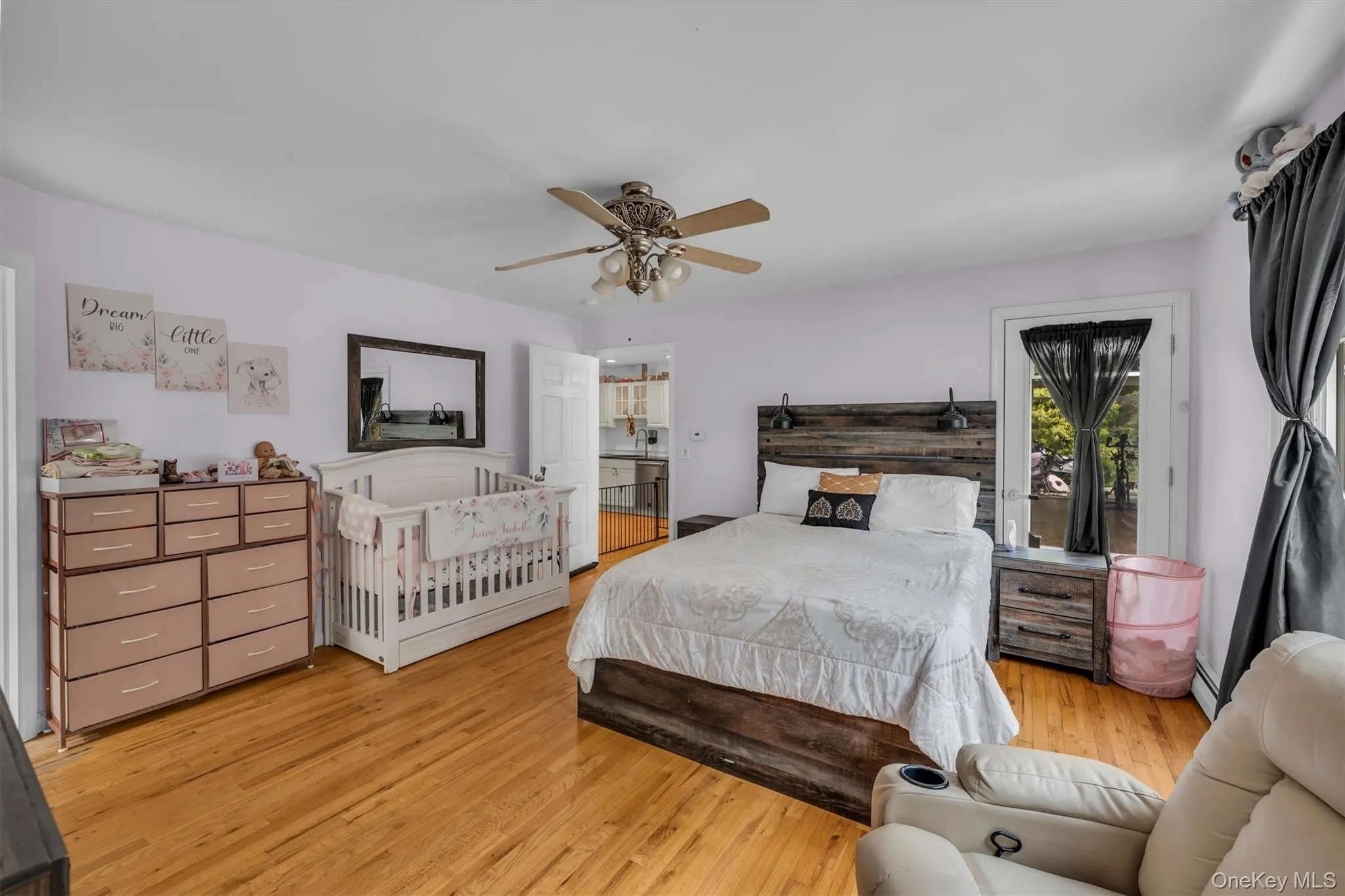 Bedroom with access to outside, light wood finished floors, ceiling fan, and a baseboard heating unit Bedroom with access to outside, light wood finished floors, ceiling fan, and a baseboard heating unit