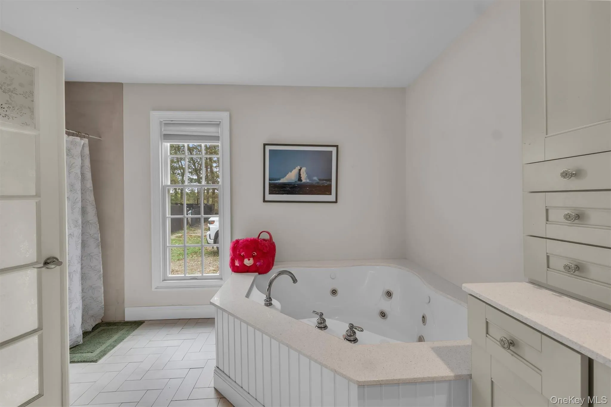 Full bath featuring a whirlpool tub, light tile patterned flooring, and a shower with curtain Full bath featuring a whirlpool tub, light tile patterned flooring, and a shower with curtain