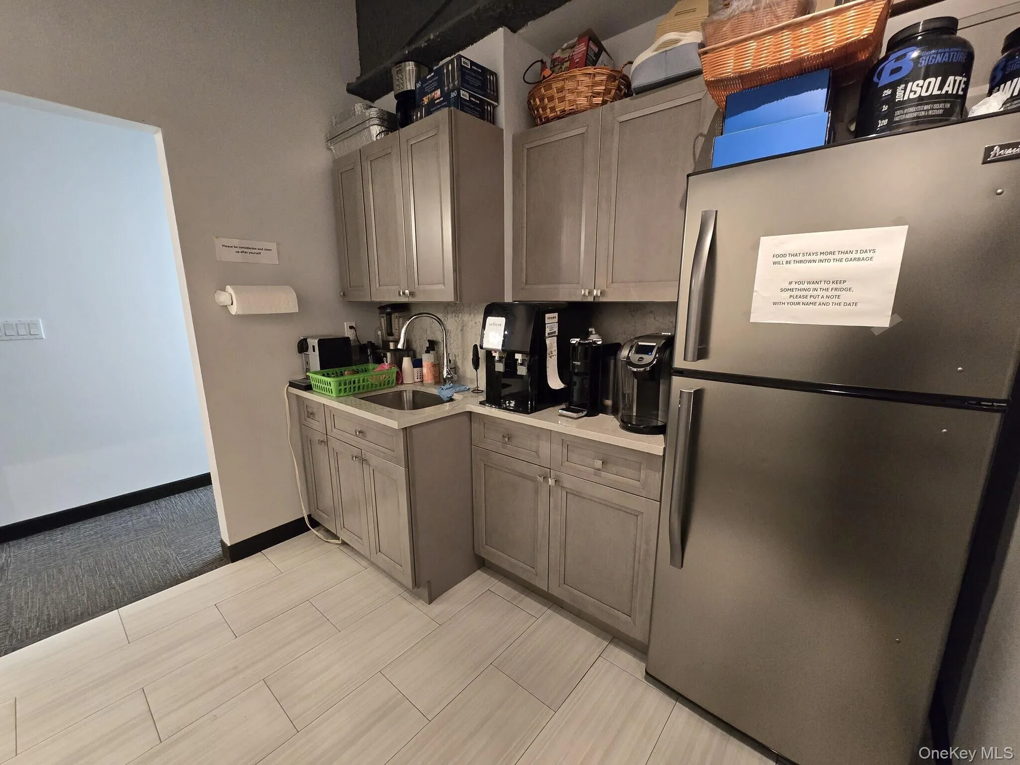 Kitchen featuring freestanding refrigerator and gray cabinetry Kitchen featuring freestanding refrigerator and gray cabinetry