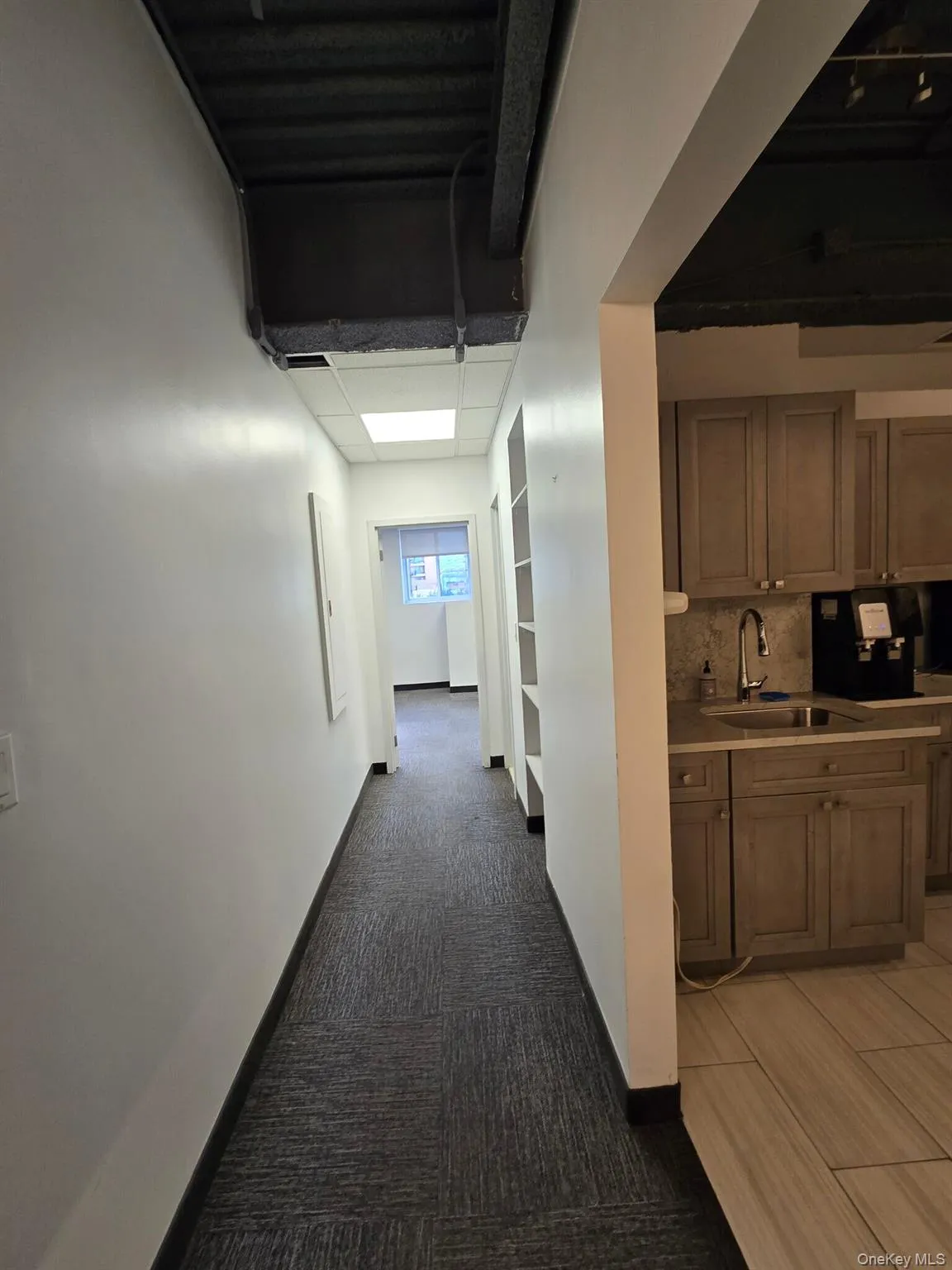 Hallway featuring light carpet and baseboards Hallway featuring light carpet and baseboards