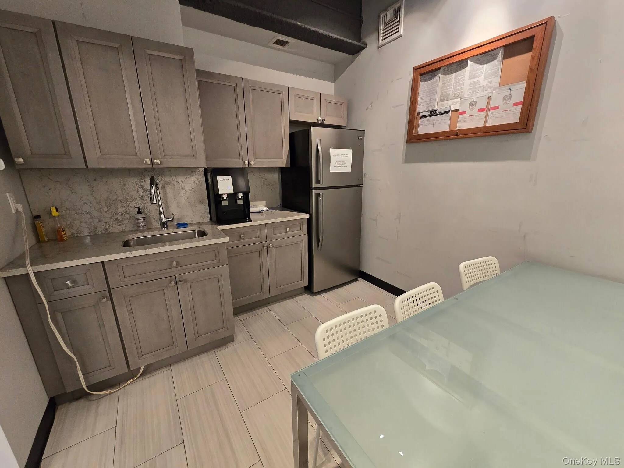 Kitchen featuring freestanding refrigerator and decorative backsplash Kitchen featuring freestanding refrigerator and decorative backsplash