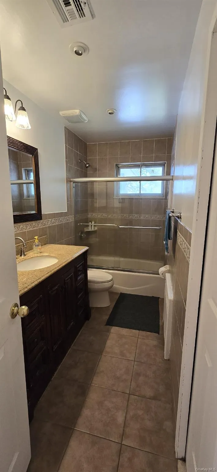 Bathroom featuring a dark wood-finish vanity with a stone countertop and undermount sink Bathroom featuring a dark wood-finish vanity with a stone countertop and undermount sink