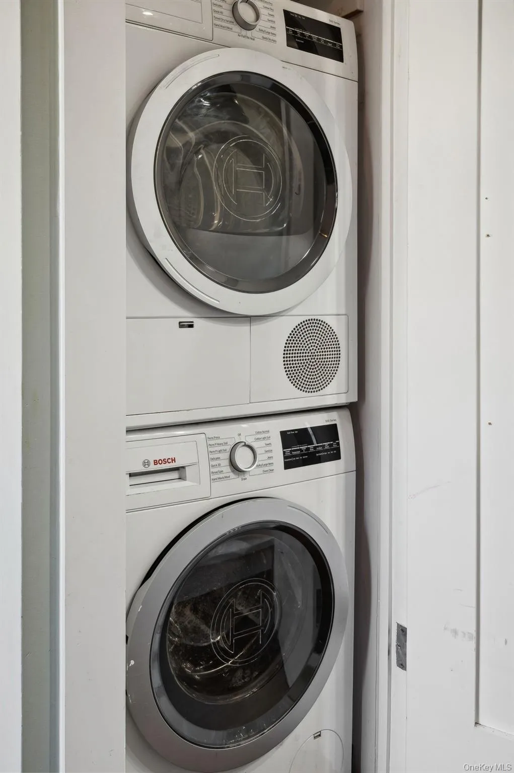 Washroom featuring stacked washer / drying machine Washroom featuring stacked washer / drying machine