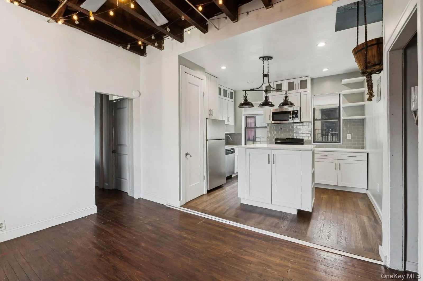 Kitchen featuring white cabinets, glass insert cabinets, dark wood finished floors, and a kitchen island Kitchen featuring white cabinets, glass insert cabinets, dark wood finished floors, and a kitchen island