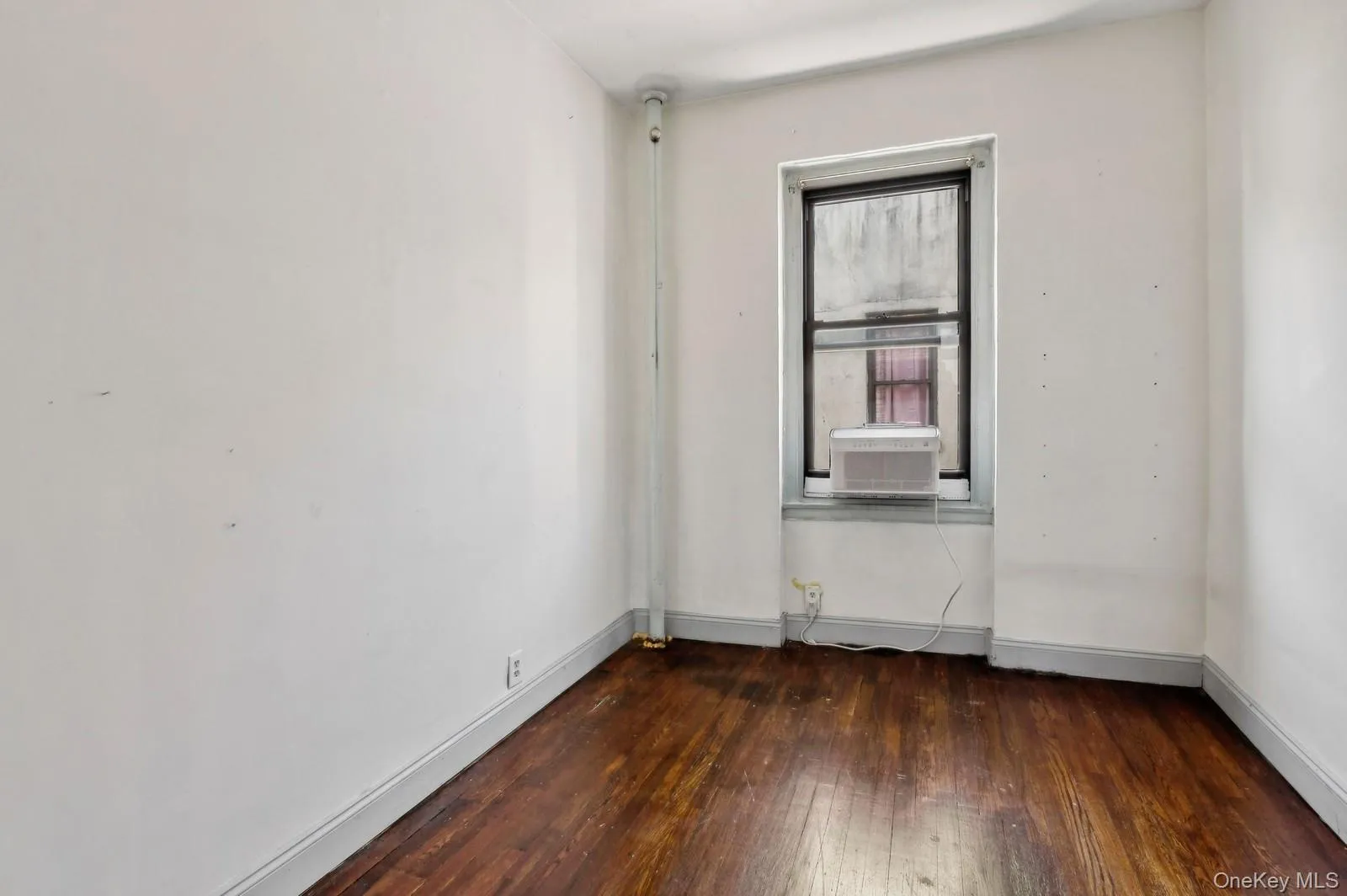 Empty room featuring dark wood-type flooring and cooling unit Empty room featuring dark wood-type flooring and cooling unit