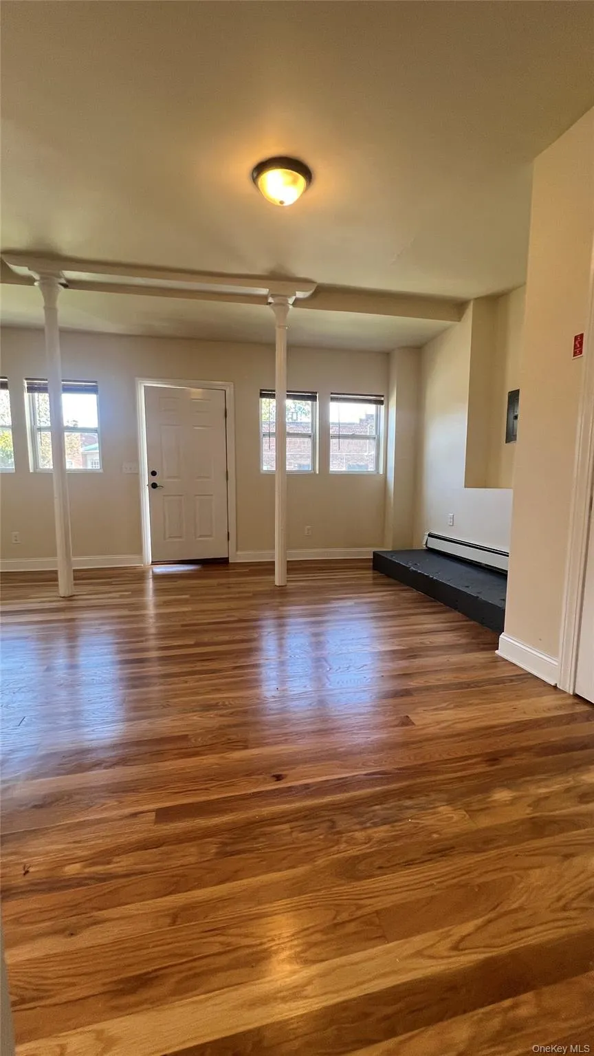 Entryway featuring wood finished floors, healthy amount of natural light, and baseboard heating Entryway featuring wood finished floors, healthy amount of natural light, and baseboard heating
