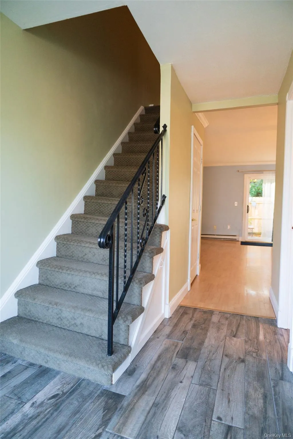 Staircase with wood finished floors and a baseboard heating unit Staircase with wood finished floors and a baseboard heating unit