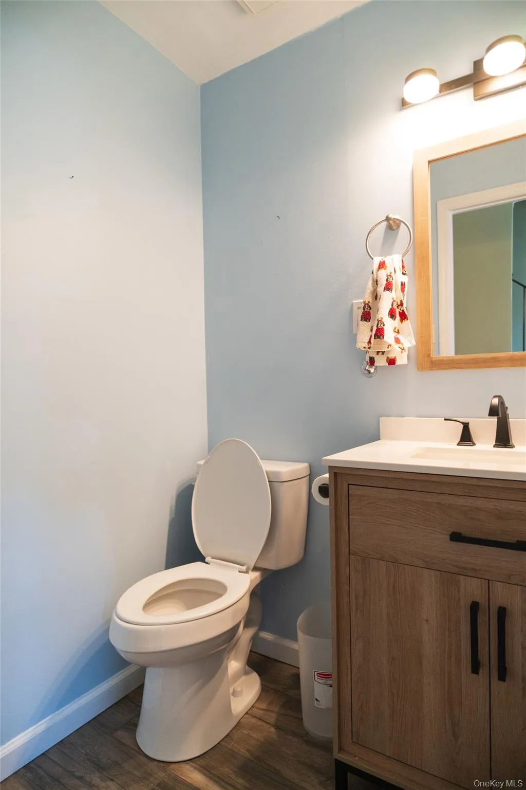 Half bath featuring vanity and dark wood-style floors Half bath featuring vanity and dark wood-style floors