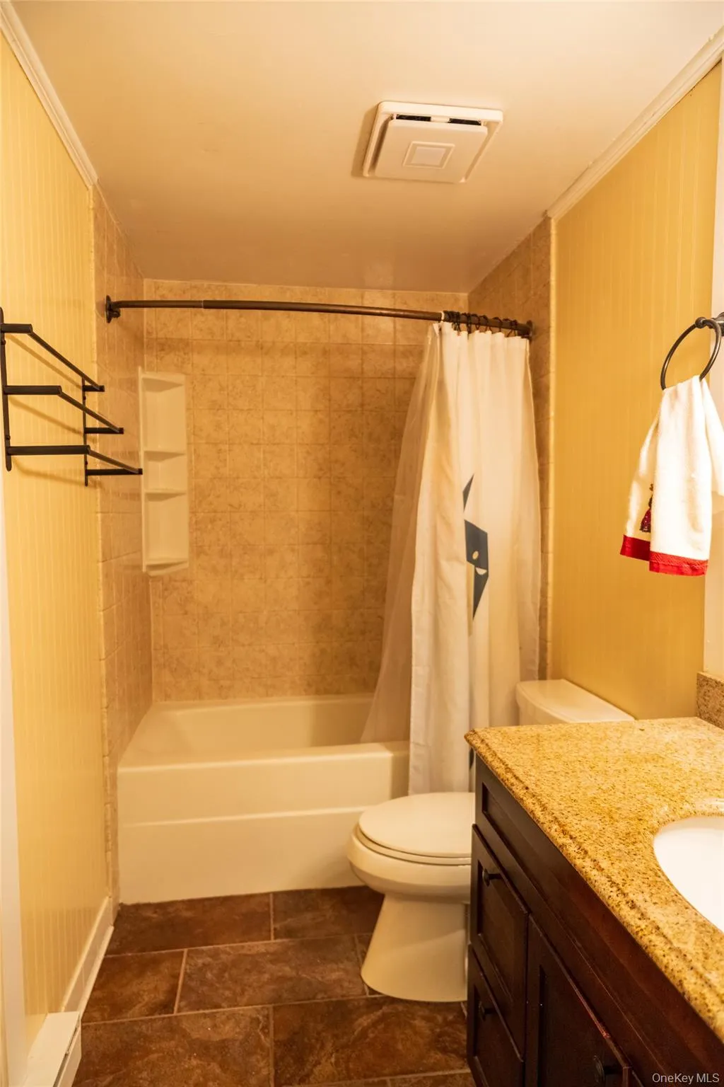 Bathroom featuring shower / bath combo with shower curtain, vanity, and crown molding Bathroom featuring shower / bath combo with shower curtain, vanity, and crown molding