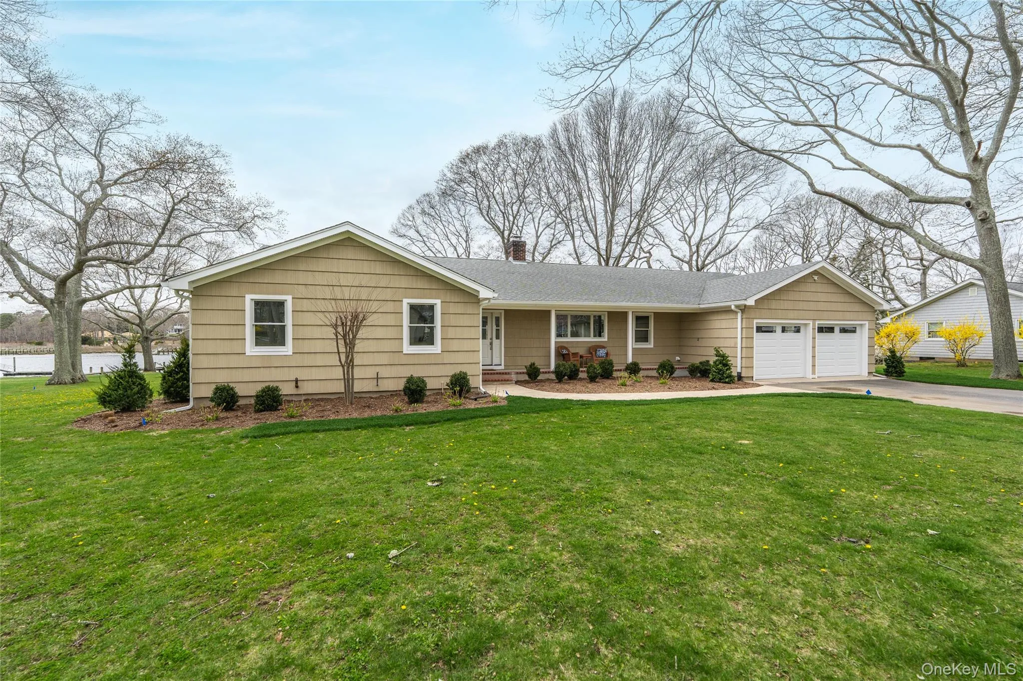 Ranch-style house with driveway, a chimney, a front yard, and a garage Ranch-style house with driveway, a chimney, a front yard, and a garage