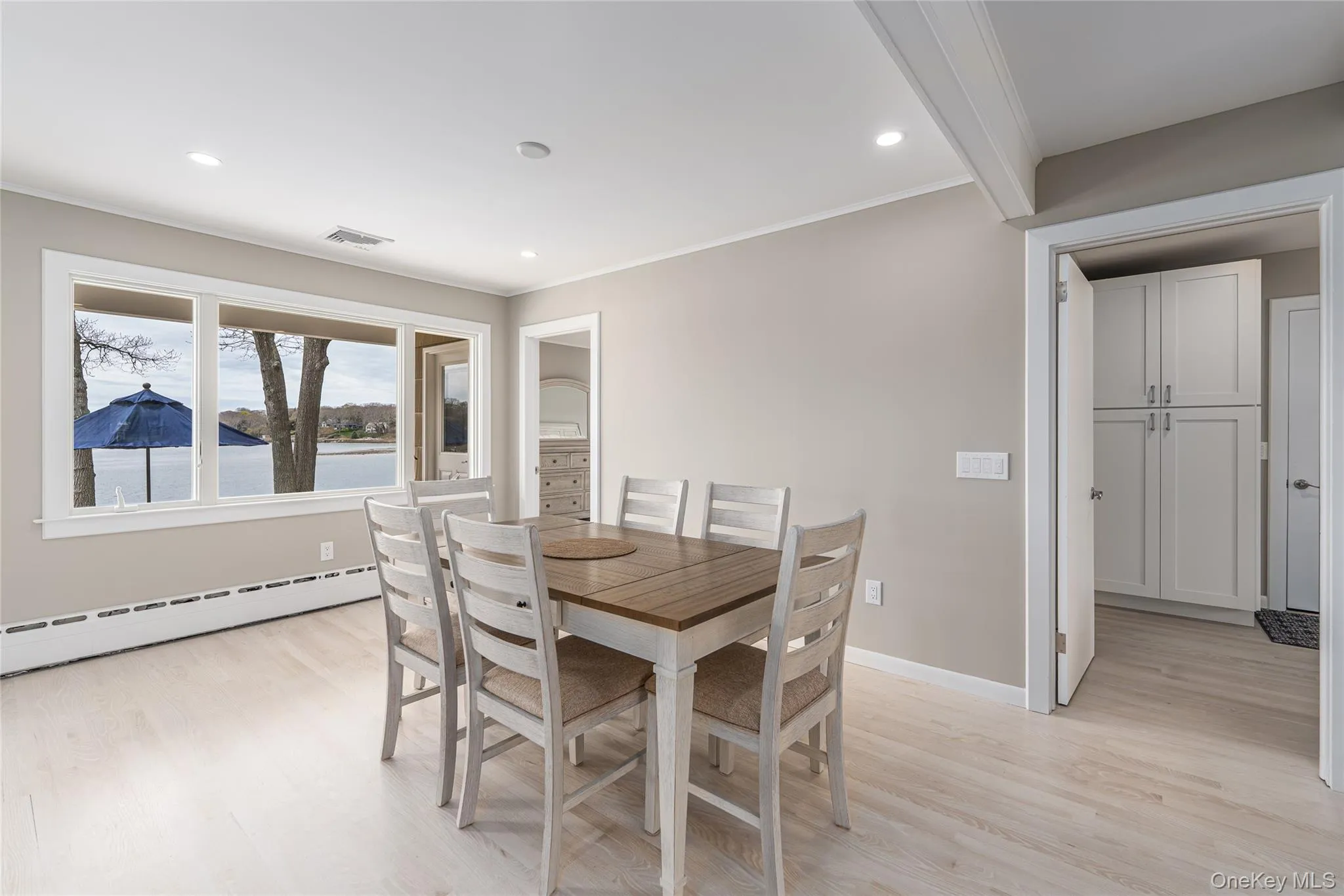 Dining space with baseboard heating, visible vents, crown molding, and light wood finished floors Dining space with baseboard heating, visible vents, crown molding, and light wood finished floors