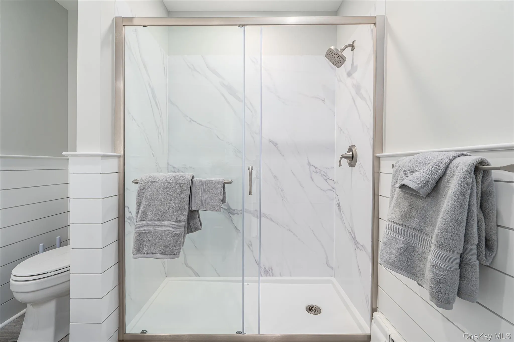 Bathroom featuring toilet and a marble finish shower Bathroom featuring toilet and a marble finish shower