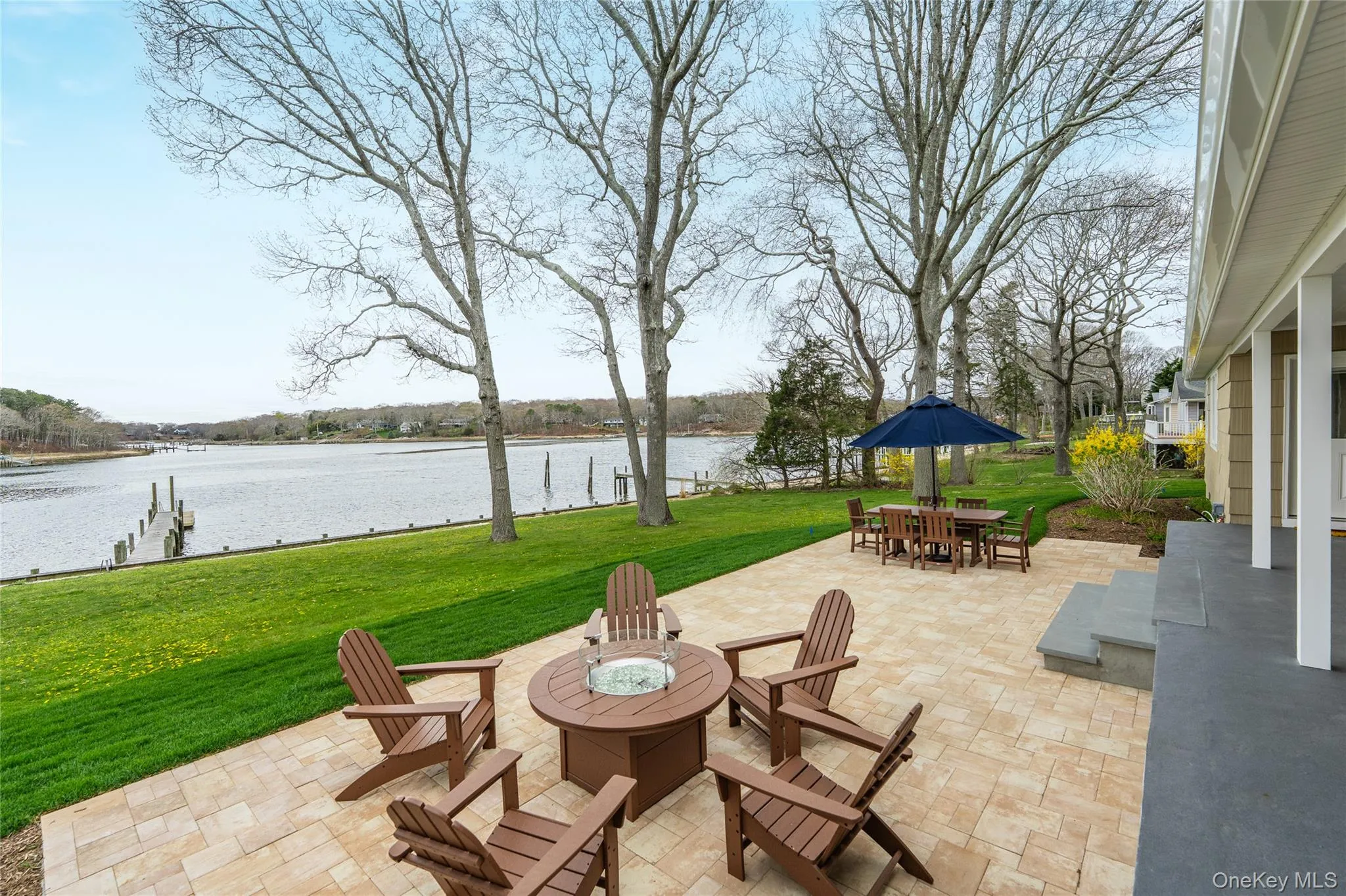 View of patio with a fire pit, a water view, and outdoor dining space View of patio with a fire pit, a water view, and outdoor dining space