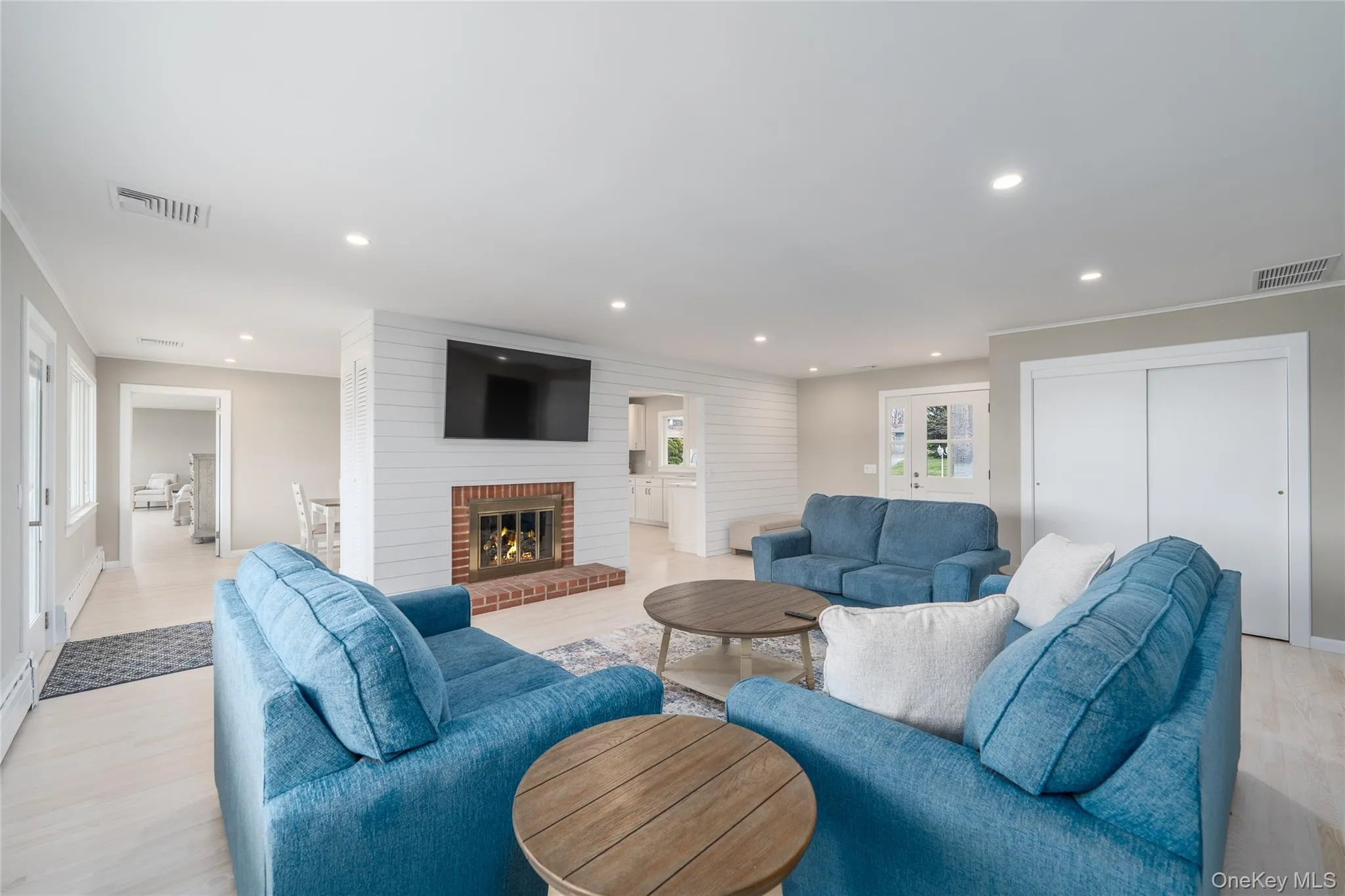 Living area with visible vents, recessed lighting, and light wood-style floors Living area with visible vents, recessed lighting, and light wood-style floors