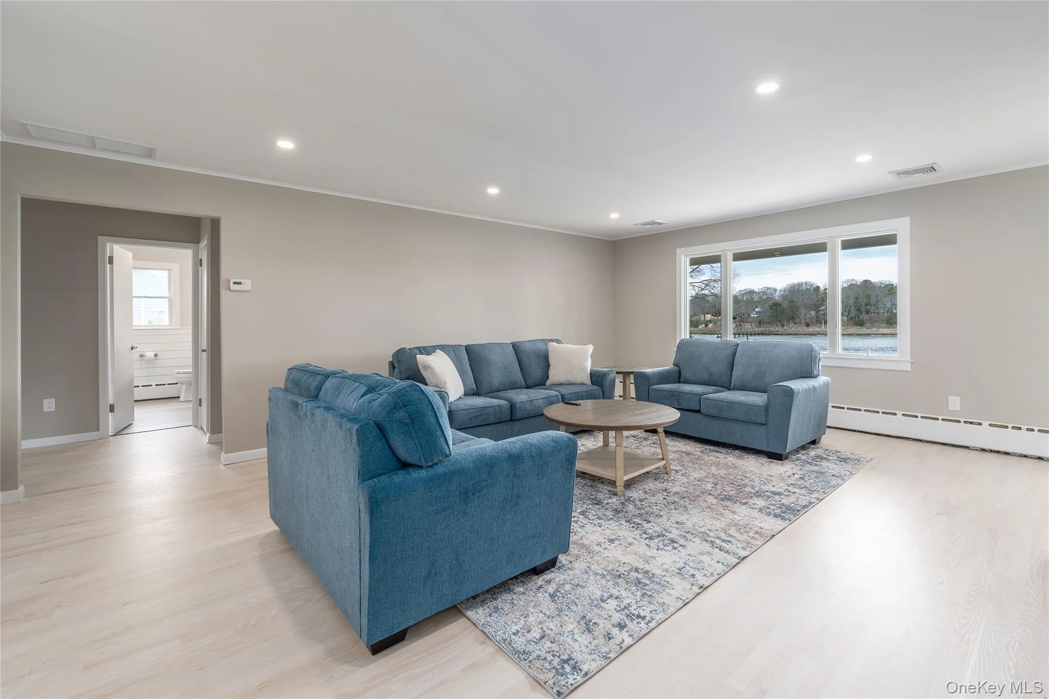 Living area with visible vents, light wood-type flooring, and plenty of natural light Living area with visible vents, light wood-type flooring, and plenty of natural light