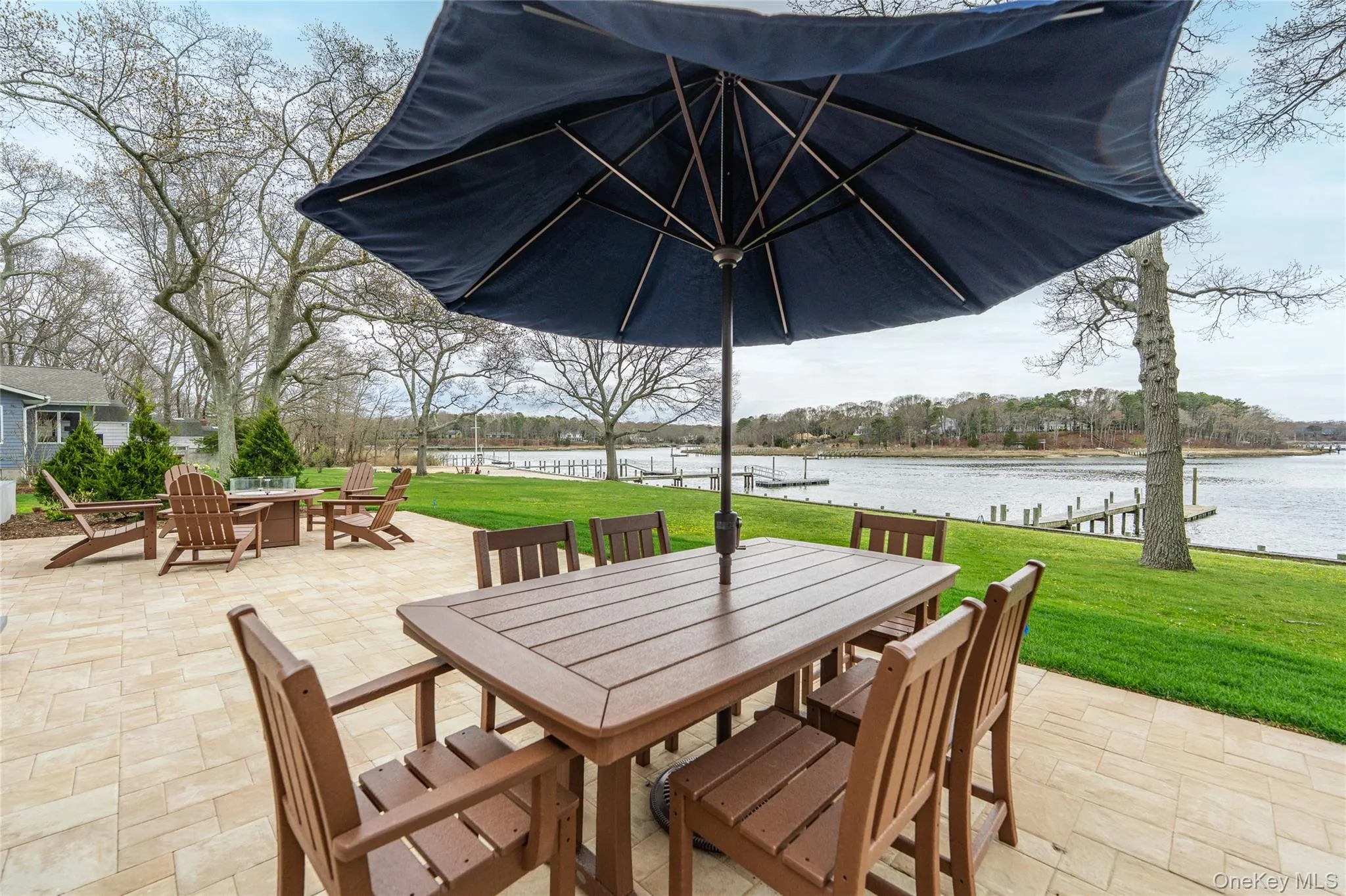 View of patio with outdoor dining space, a fire pit, and a water view View of patio with outdoor dining space, a fire pit, and a water view