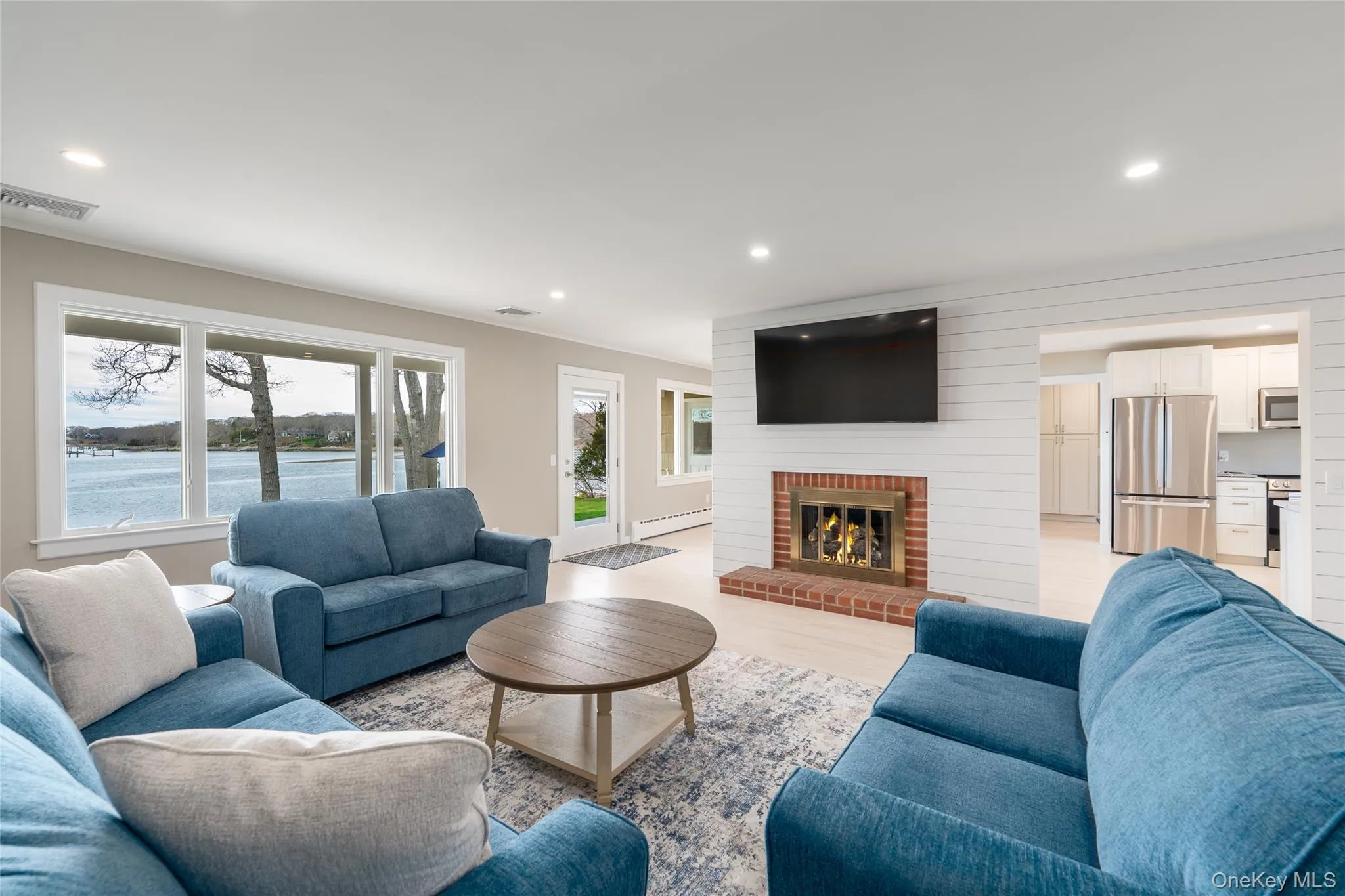 Living area with visible vents, a wealth of natural light, a fireplace, and recessed lighting Living area with visible vents, a wealth of natural light, a fireplace, and recessed lighting