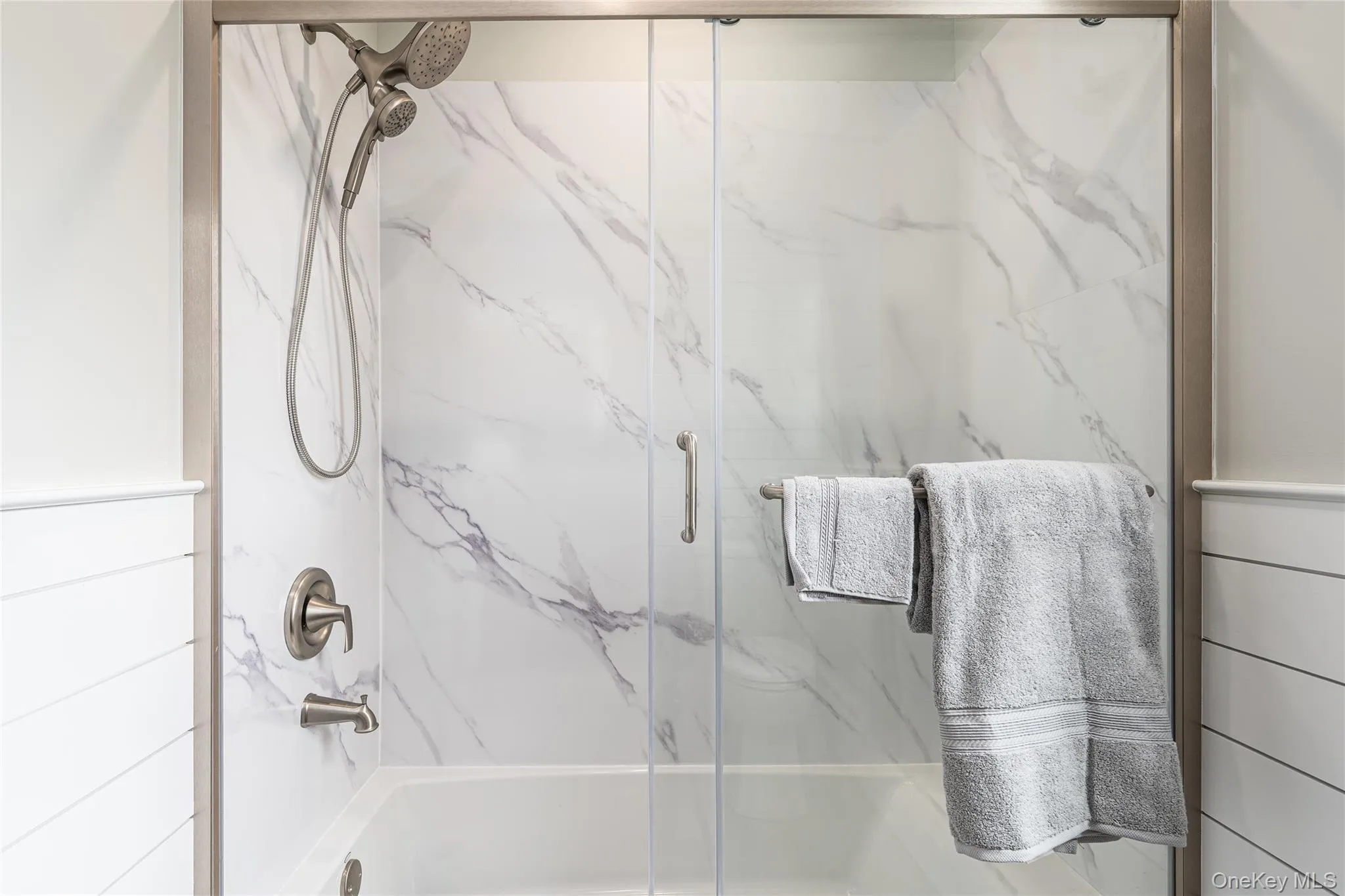 Full bathroom featuring bath / shower combo with glass door Full bathroom featuring bath / shower combo with glass door