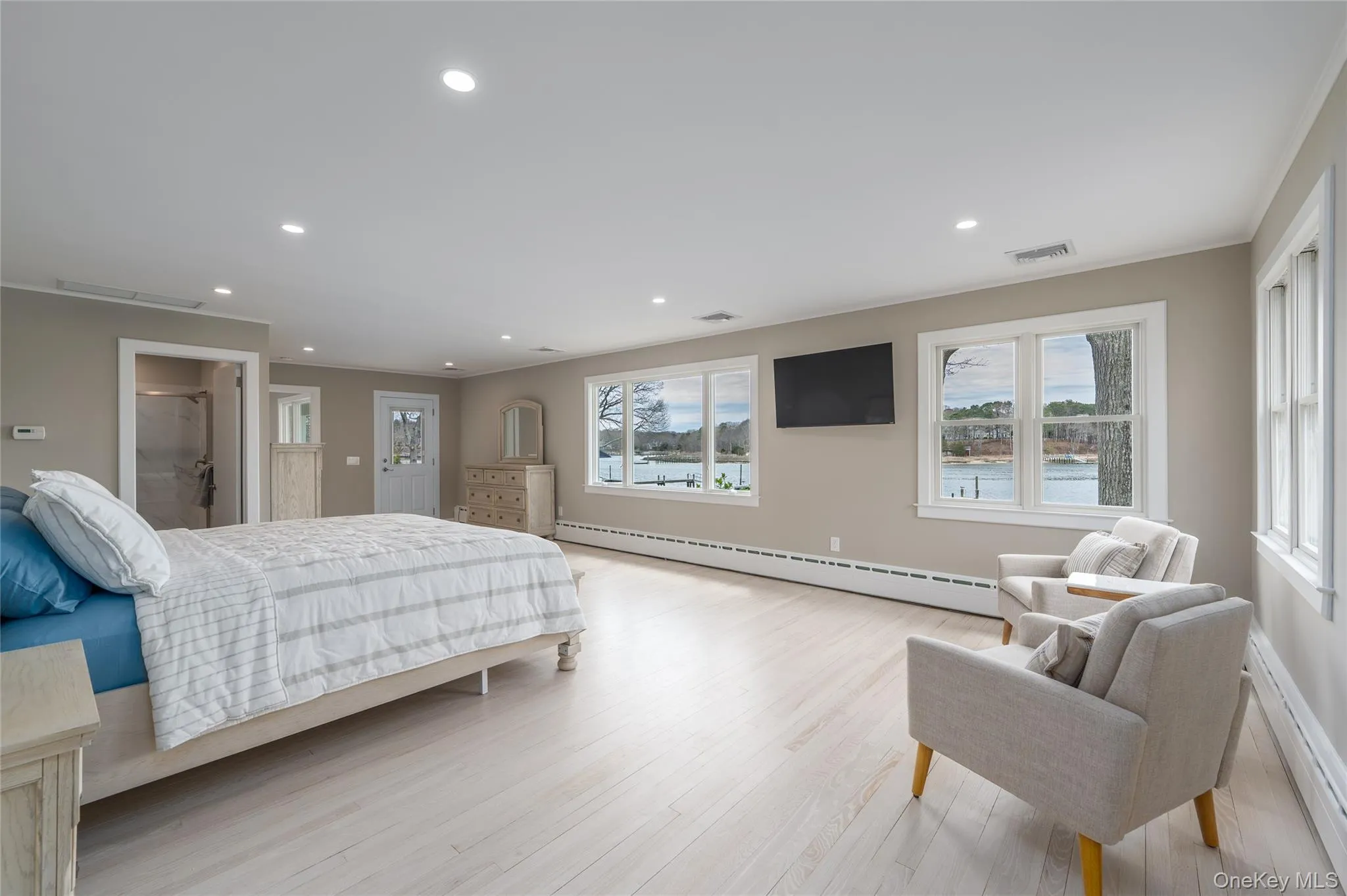 Bedroom with visible vents, recessed lighting, light wood-style floors, and a baseboard radiator Bedroom with visible vents, recessed lighting, light wood-style floors, and a baseboard radiator